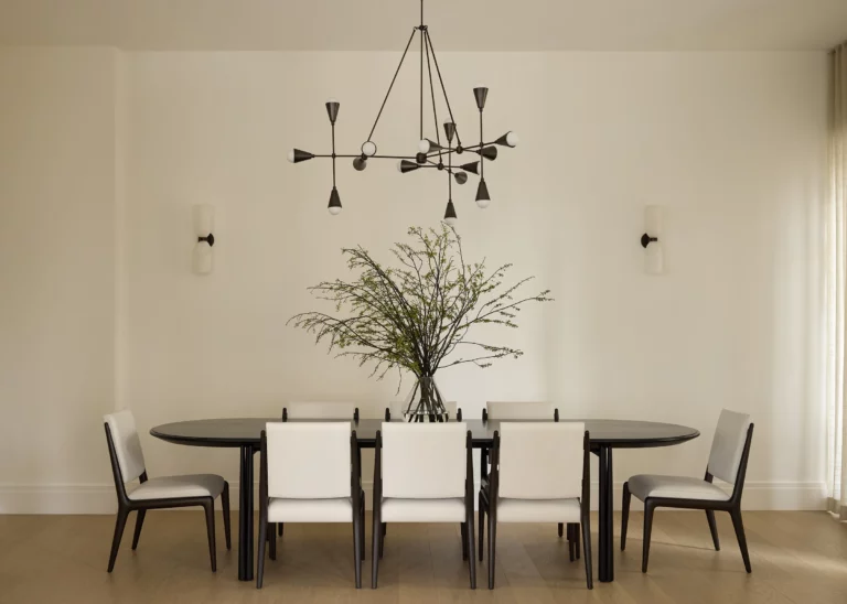 Formal dining room in a Snøhetta Upper West Side residence featuring an elongated oval table, sculptural chandelier, and a restrained palette designed for large family gatherings.