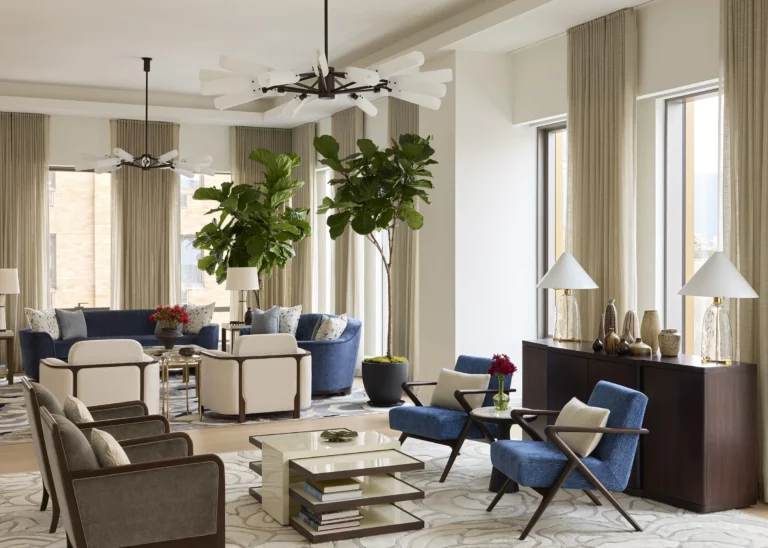 Wide view of interconnected entertaining rooms in a Snøhetta Upper West Side podium residence, with layered seating groups, tall windows on multiple exposures, and curated furnishings for family gatherings.