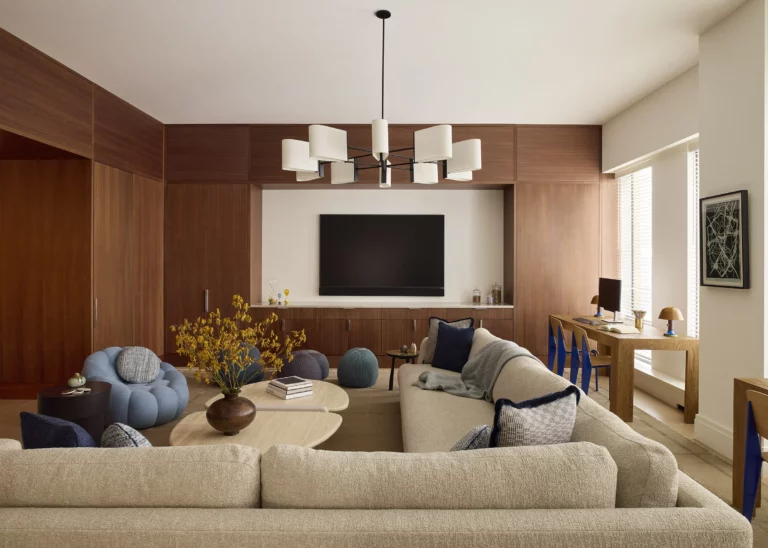 Family media room in a Snøhetta Upper West Side apartment with custom wood millwork, an integrated media wall, and a built-in desk area designed for everyday family use.